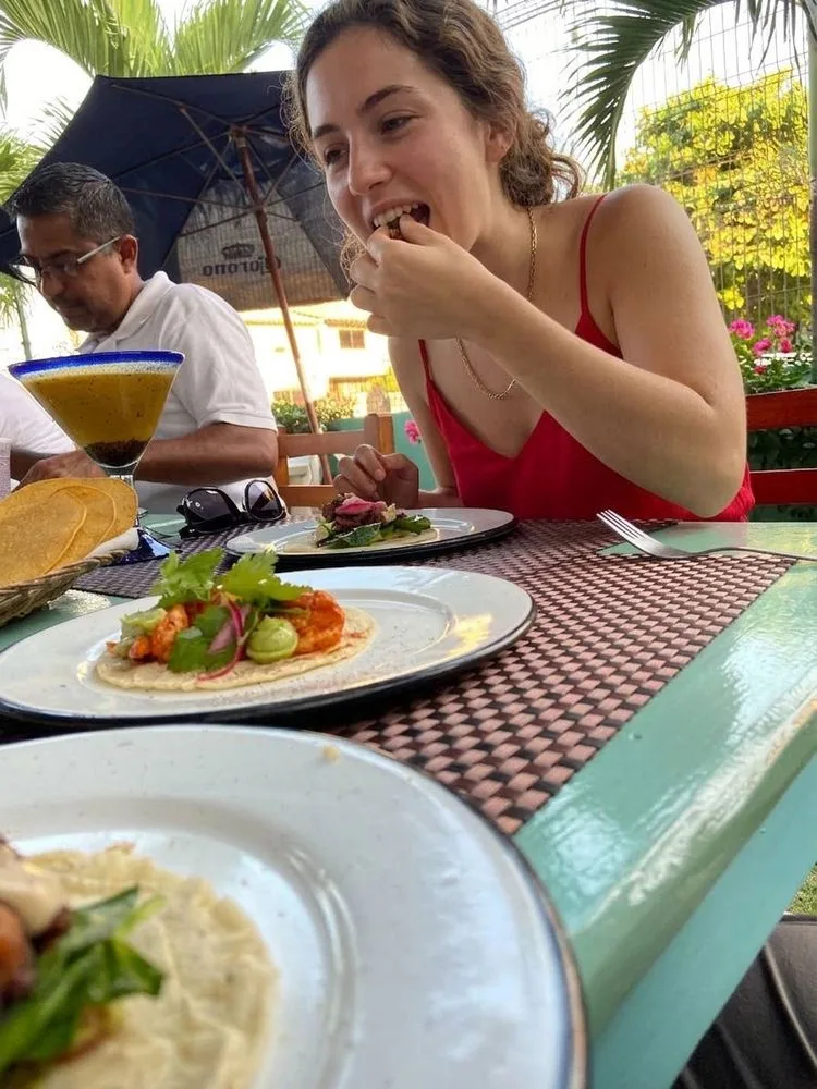A guest tasting a taco at an outdoor restaurant table in San José del Cabo