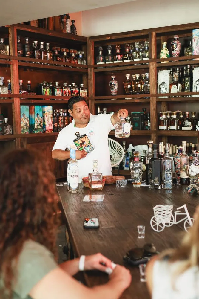 A Juan More Taco guide presenting tequila to guests at a Cabo tasting counter