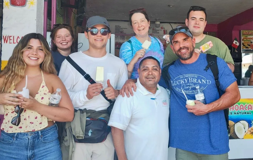 A Juan More Taco guide and guests enjoying popsicles outside a local Cabo San Lucas shop