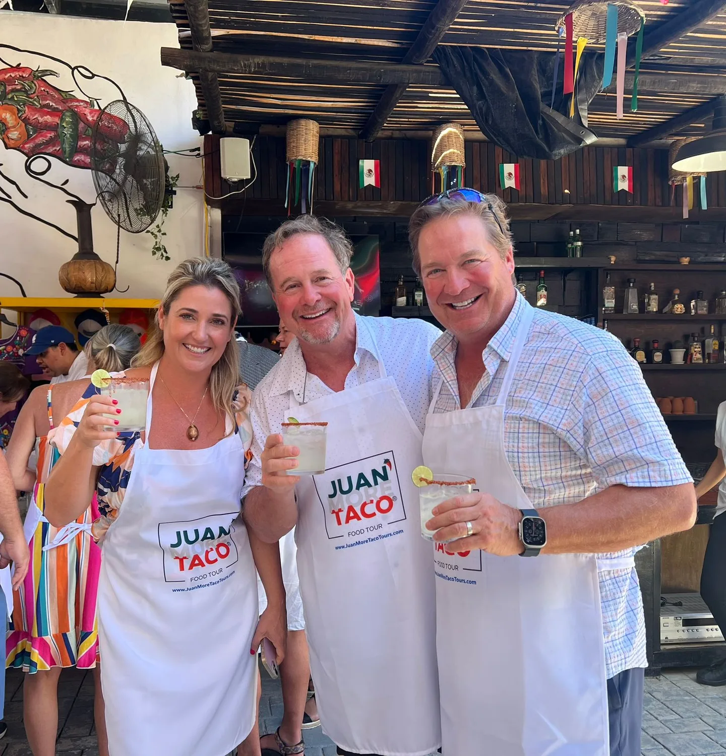 Guests wearing Juan More Taco aprons enjoying drinks during a local food tour