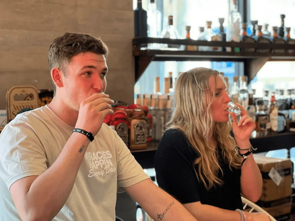 Two guests sampling tequila from tasting glasses in a Cabo San Lucas tasting room