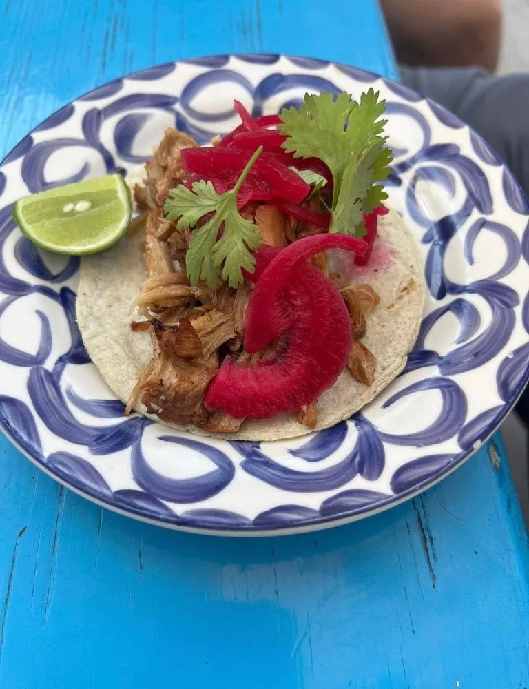 A taco topped with cilantro and pickled onion on a blue-and-white plate in San José del Cabo
